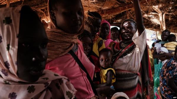 FILE - Mothers wait at a malnutrition centre to register for food aid for their children in the Tiamushro camp for internally displaced persons (IDP) in Kadugli, Sudan, on June 17, 2024.